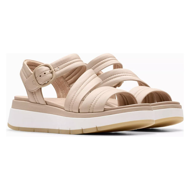 Stay stylish and supported with the Clarks Tuscan Strap sandal in beige leather, featuring a cushioned footbed and a lightweight 50mm platform heel. Style #26181475.