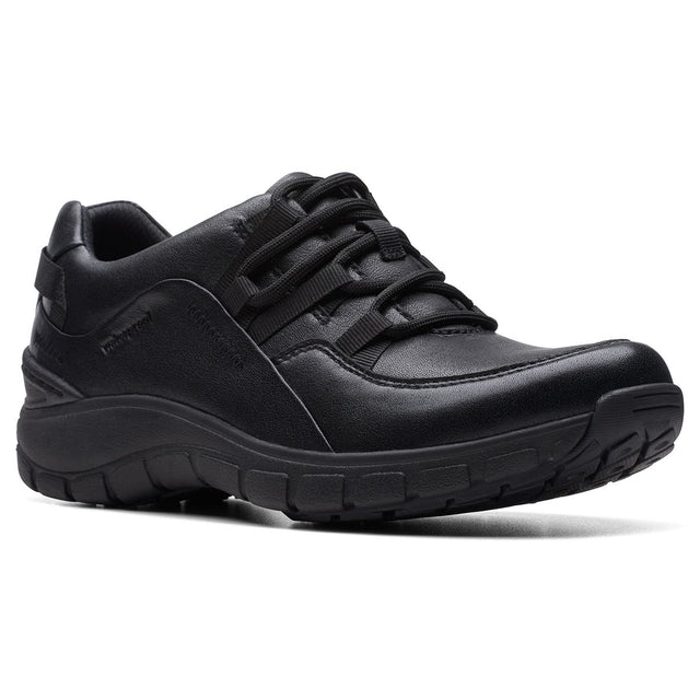 Women’s all-black leather walking sneaker featuring integrated athletic laces and a thick, textured black sole. Style #26174865.