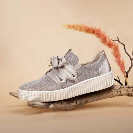 Silver glitter Gabor sneaker with white sole on a wooden branch against a beige background