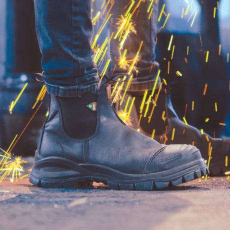 Black safety Blundstone boot with sparks in the background