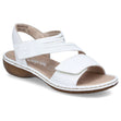 Women’s white leather sandal with adjustable velcro straps, a tan cushioned footbed, and a low wedge heel. Style #65964-80.