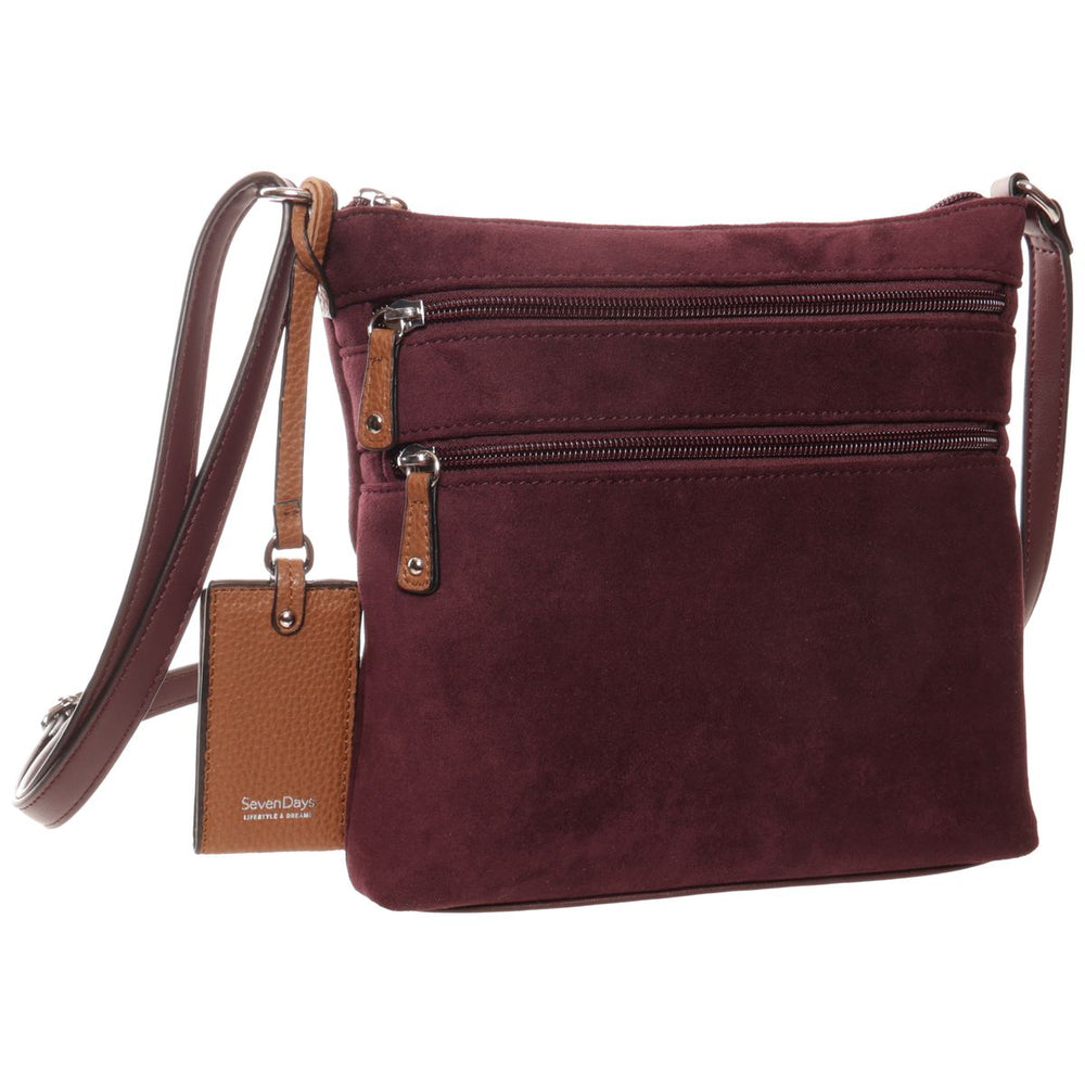 Seven Days burgundy suede crossbody handbag featuring front zip pockets, tan leather trim, and a hanging logo charm. Style #R18051STL